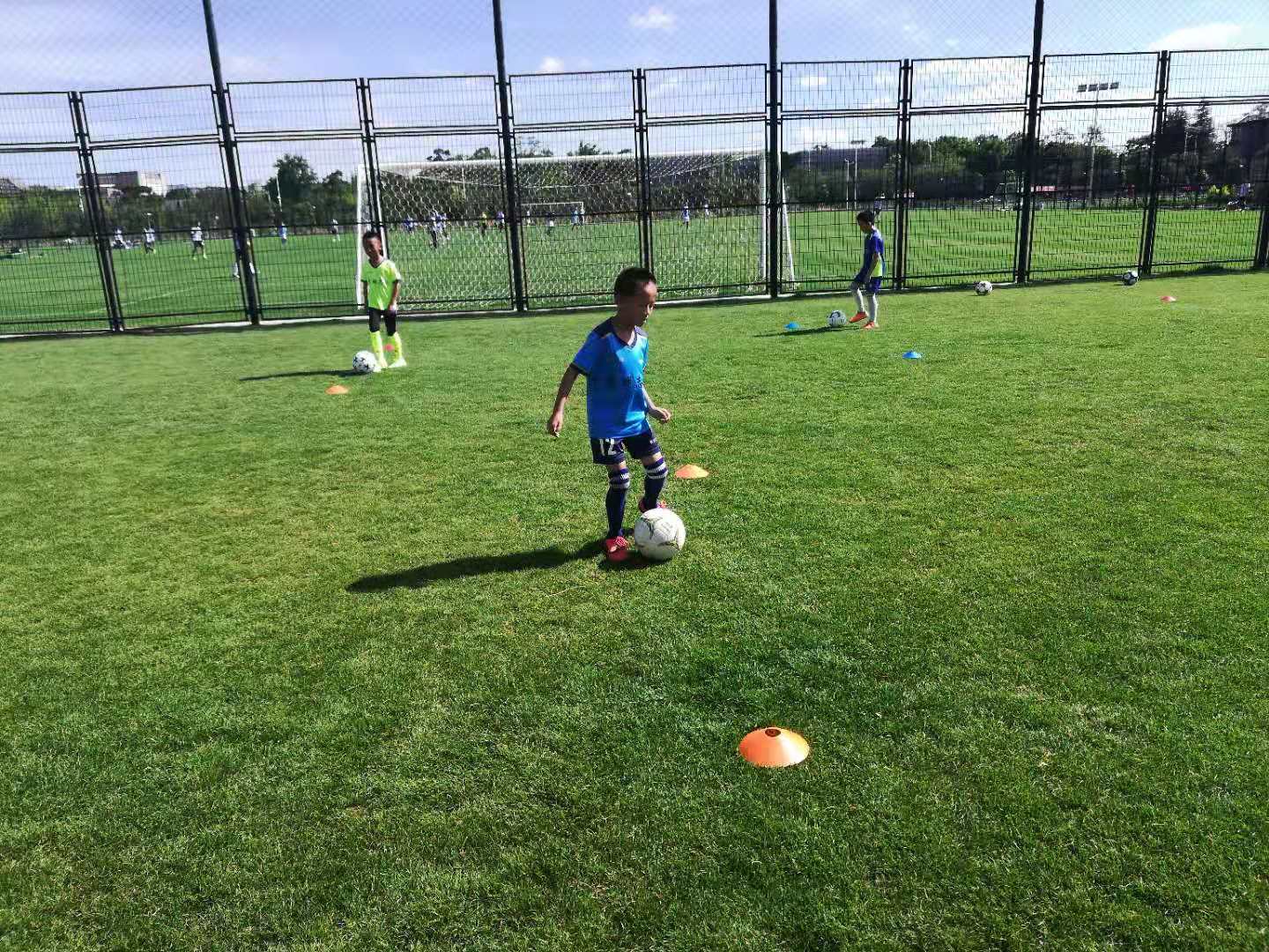 开学上学校踢球,春天到了小朋友们在草地上踢足球