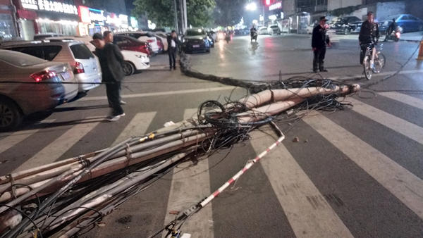 郑州闹市区两根线杆“连根拔起”，几十根线缆垂落地面阻通行