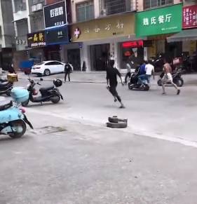 一群精神小伙打架路人拿关公刀,多人持棍棒打砸电动车